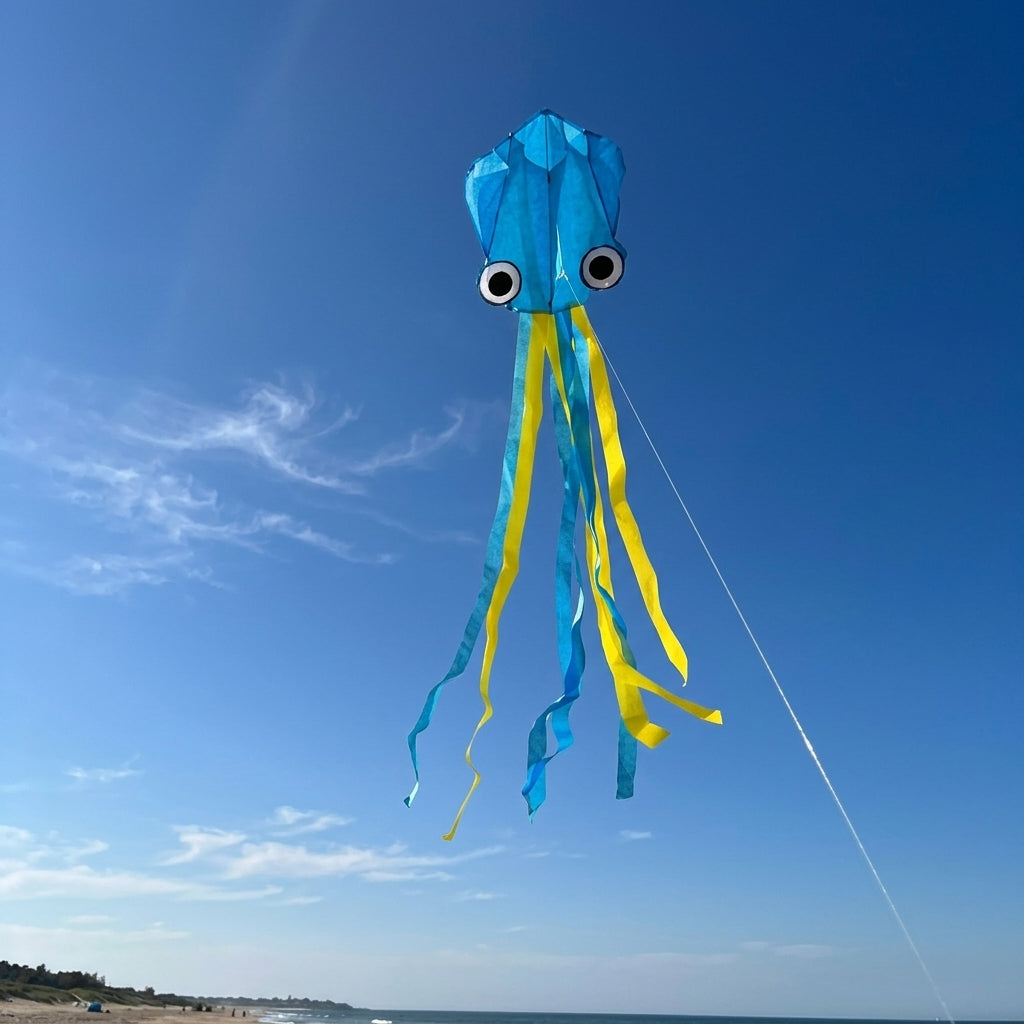 Wikz Blæksprutte drage i blå med lange haler, vist  mod himlen